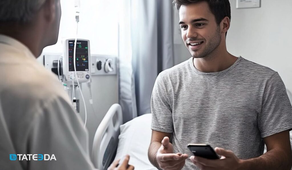 Doctor and patient communicating in a hospital setting, with the patient using a smartphone—illustrating healthcare mobile app trends in digital health. | TATEEDA